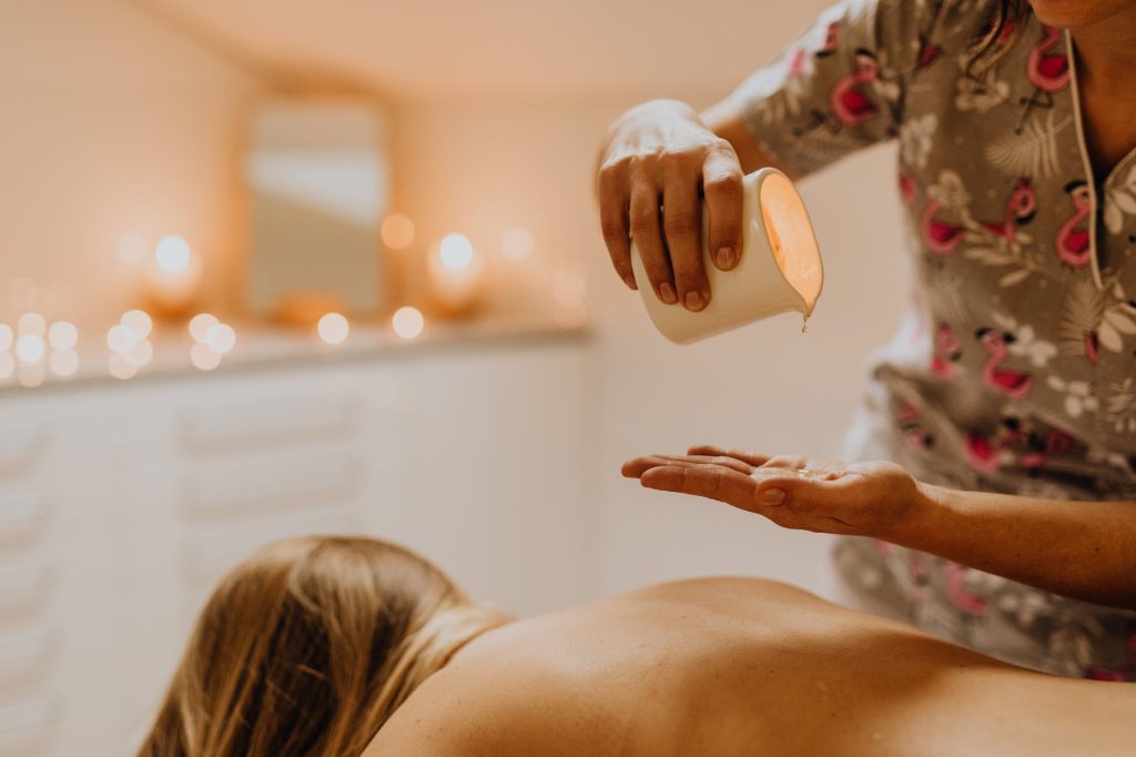 a masseuse pouring oil on her hand