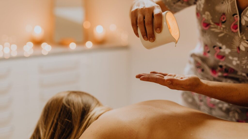 a masseuse pouring oil on her hand